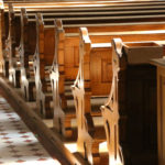 Row of wooden church pews in sunlight