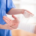 Nurse Wrapping a Wound on Mans Wrist