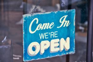 Business sign saying "Come In We're Open" in white on blue background