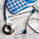 health insurance forms with stethoscope and calculator