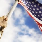 person raising the U.S. flag