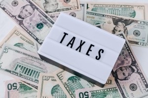 us cash with "taxes" sign on top