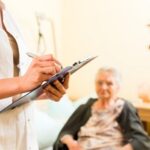 Nurse Holding Clipboard in Front of Nursing Patient