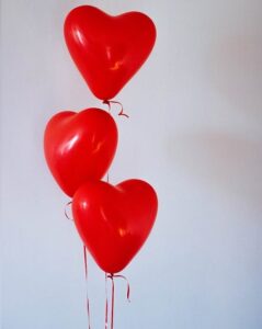 Three Red Heart Balloons Floating